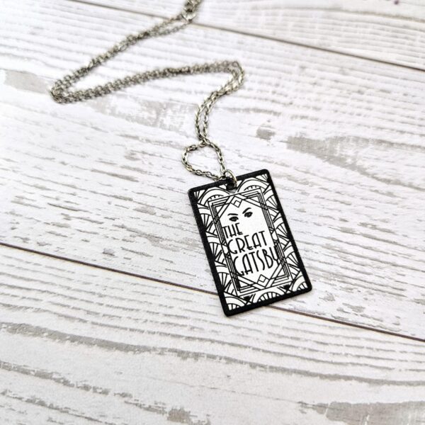 Gatsby Book Necklace – Mirror Polish Stainless Steel Literary Pendant 6 Great Gatsby miniature book pendant — mirror-polish stainless steel, engraved in-house. Tarnish-proof literary jewelry for the classic literature lover. “So we beat on, boats against the current...” 🍸✨ Capture the glittering allure of West Egg with our Mirror Polish Great Gatsby Necklace. This isn't just a book charm; it’s a high-shine statement piece designed for those who find beauty in the classics. Crafted from 304 Stainless Steel and polished to a brilliant, reflective finish, it mimics the (6)
