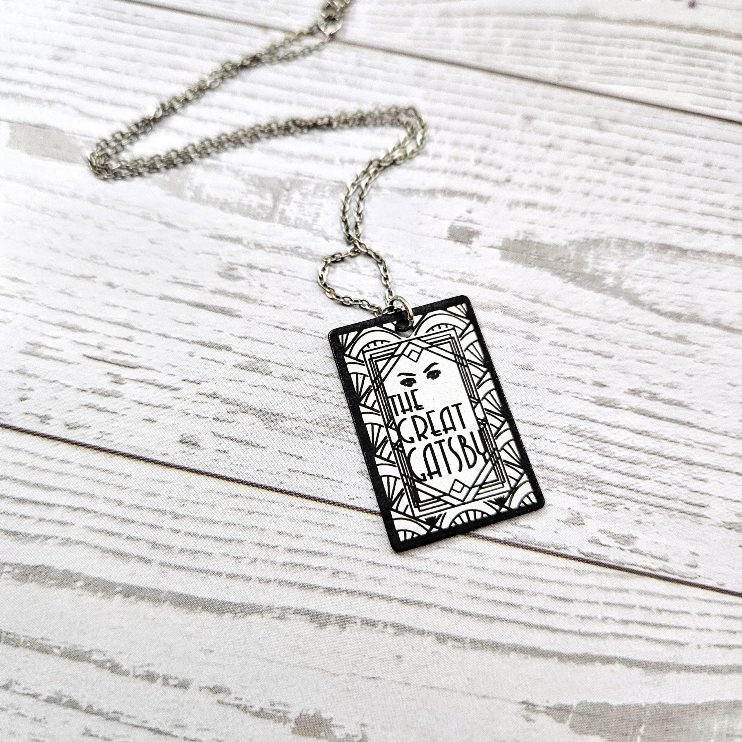 Great Gatsby miniature book pendant — mirror-polish stainless steel, engraved in-house. Tarnish-proof literary jewelry for the classic literature lover. “So we beat on, boats against the current...” 🍸✨ Capture the glittering allure of West Egg with our Mirror Polish Great Gatsby Necklace. This isn't just a book charm; it’s a high-shine statement piece designed for those who find beauty in the classics. Crafted from 304 Stainless Steel and polished to a brilliant, reflective finish, it mimics the (6)