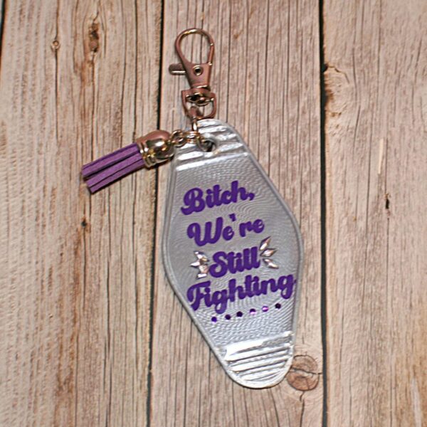 il_fullxfull.7629582991_h5mx Protest Motel Keychain - Bitch, We’re Still Fighting Keychain