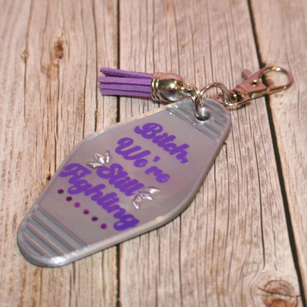 il_fullxfull.7629583259_ahk5 Protest Motel Keychain - Bitch, We’re Still Fighting Keychain