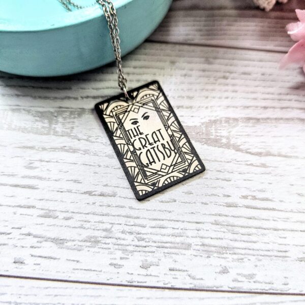 Gatsby Book Necklace – Mirror Polish Stainless Steel Literary Pendant 3 Great Gatsby miniature book pendant — mirror-polish stainless steel, engraved in-house. Tarnish-proof literary jewelry for the classic literature lover. “So we beat on, boats against the current...” 🍸✨ Capture the glittering allure of West Egg with our Mirror Polish Great Gatsby Necklace. This isn't just a book charm; it’s a high-shine statement piece designed for those who find beauty in the classics. Crafted from 304 Stainless Steel and polished to a brilliant, reflective finish, it mimics the (3)