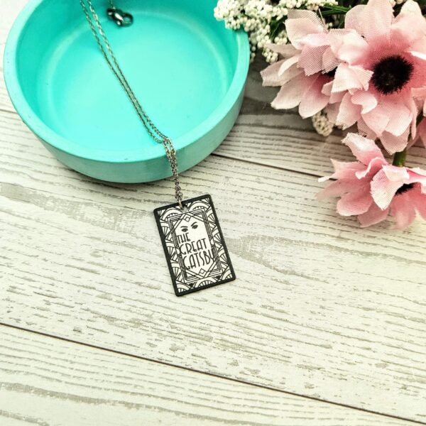 Gatsby Book Necklace – Mirror Polish Stainless Steel Literary Pendant 4 Great Gatsby miniature book pendant — mirror-polish stainless steel, engraved in-house. Tarnish-proof literary jewelry for the classic literature lover. “So we beat on, boats against the current...” 🍸✨ Capture the glittering allure of West Egg with our Mirror Polish Great Gatsby Necklace. This isn't just a book charm; it’s a high-shine statement piece designed for those who find beauty in the classics. Crafted from 304 Stainless Steel and polished to a brilliant, reflective finish, it mimics the (4)