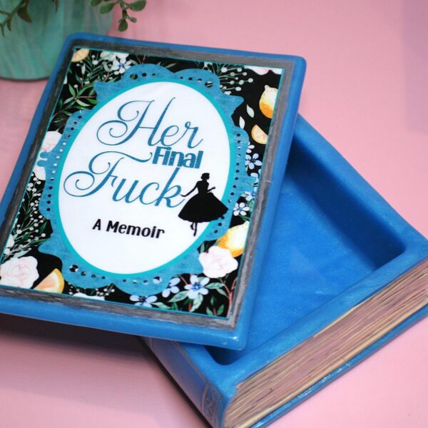 Handmade Resin Book Box: "Her Final Fuck... A Memoir" - Blue Floral Keepsake Storage 1 Some books hold stories—this one holds secrets. 💙✨ Introducing the handmade resin book box in a striking bright blue hue, designed for book lovers who appreciate a little edge with their elegance. Crafted with tinted epoxy resin, this durable and stylish storage box blends effortlessly into your bookshelf, making it the perfect spot to stash your small treasures. ✨ Features: 📖 Expertly crafted from high-quality epoxy resin – glossy, sturdy, and built to last. The boxes can stand a drop but will (1)