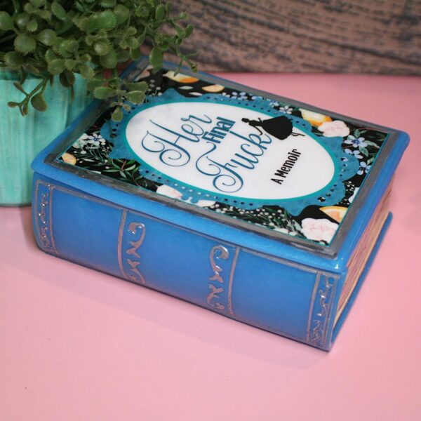 Handmade Resin Book Box: "Her Final Fuck... A Memoir" - Blue Floral Keepsake Storage 6 Some books hold stories—this one holds secrets. 💙✨ Introducing the handmade resin book box in a striking bright blue hue, designed for book lovers who appreciate a little edge with their elegance. Crafted with tinted epoxy resin, this durable and stylish storage box blends effortlessly into your bookshelf, making it the perfect spot to stash your small treasures. ✨ Features: 📖 Expertly crafted from high-quality epoxy resin – glossy, sturdy, and built to last. The boxes can stand a drop but will (6)