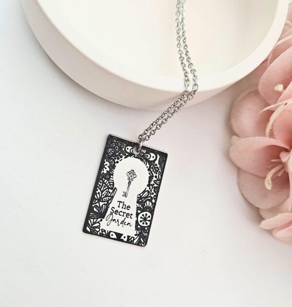 Secret Garden Book Necklace – Engraved Miniature Book Pendant – Literary Jewelry Gift 2 Secret Garden miniature book pendant — mirror-polish stainless steel, engraved in-house. Cottagecore literary gift for the book lover, gardener, or dreamer. “If you look the right way, you can see that the whole world is a garden.” 🌿🗝️ Unlock a bit of magic with our Secret Garden Book Necklace. A tribute to Frances Hodgson Burnett’s beloved tale of hidden beauty and second chances, this pendant is designed for the dreamers who believe in the power of growth. Whether you’re a lifelong reader or a (2)