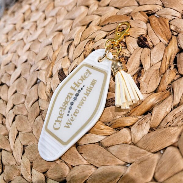 Vintage Chelsea Hotel Motel Keychain – Gothic Rhinestone Bag Charm 1 Embrace the brooding romance and moody nostalgia of the legendary Chelsea Hotel aesthetic with this vintage-inspired motel keychain. Perfect for the poetic souls, late-night writers, and lovers of timeless, slightly dramatic flair. Featuring the slightly tragic yet entirely relatable phrase "We're two idiots" in sleek matte gold vinyl, it is a nod to those beautifully chaotic moments shared between fellow creatives, book nerds, and star-crossed friends. Product Details: - Vintage Appeal: Gorgeou (1)
