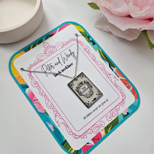 Engraved Peter and Wendy Book Necklace – Stainless Steel Literary Jewelry 2 Miniature Peter and Wendy book pendant, engraved in-house with original cover art. Mirror-polish stainless steel, tarnish-proof. A gift for every lost girl. “To live would be an awfully big adventure.” ✨🧚♂️ Fly away to Neverland with a piece of jewelry as unique as the story itself. Our Peter and Wendy Book Necklace features original cover art designed in our studio, making this a one-of-a-kind tribute you won't find anywhere else. Forget mass-produced charms. Each pendant is engraved in-house (2)