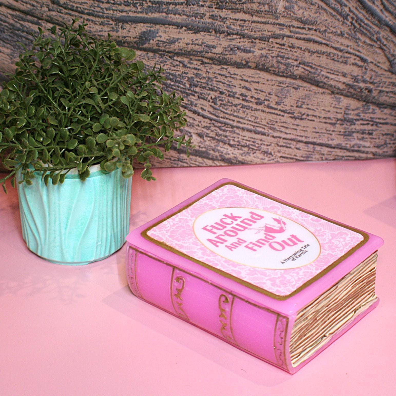 Hide your treasures in plain sight with this handmade resin book box—a sassy and stylish storage solution for any book lover! Designed to blend seamlessly into your bookshelf or desk, this epoxy resin book box is both functional and eye-catching. ✨ Features: 📖 Handcrafted with high-quality tinted epoxy resin – durable, glossy, and built to last. 🎨 Hand-painted page details – complete with gold accents on the edges and spine for that luxury book aesthetic. 💖 Custom-designed cover – featuring a pi (4)