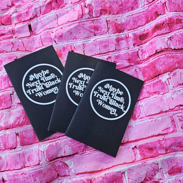 Small notebook. Powerful message. This “Maybe Next Time, Trust Black Women” mini notebook is perfect for everyday notes, thoughts, lists, and reminders that Black women know what they’re talking about. ✨ FULL DESCRIPTION This mini lined notebook features the bold statement “Maybe Next Time, Trust Black Women” in a clean, circular design on a sleek black cover. It’s compact, intentional, and made for people who like their stationery to say something meaningful. Sized to fit easily in bags, backpa (6)