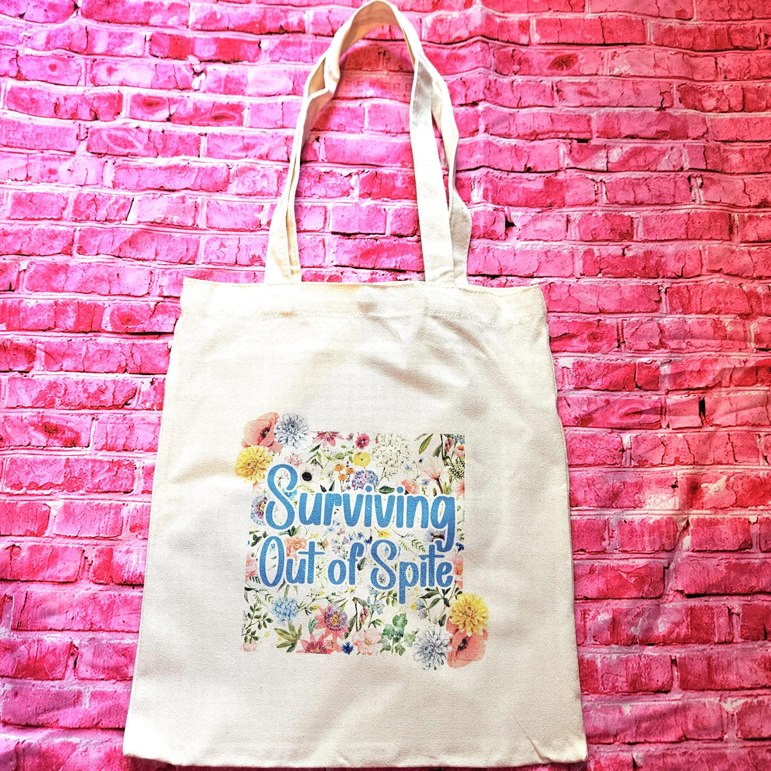 For the fiercely independent friend who thrives on proving people wrong! 💐 Give the gift of unapologetic resilience with this Surviving Out of Spite tote bag. Why this tote stands on business: 💼 Permanent Design: The design is sublimated. The ink is dyed directly into the fibers, meaning it won’t fade, rub off, or lose its punch—no matter how many times you wash it. 🧼✨ Premium Build: Made from high-quality, medium-weight cotton canvas. It’s sturdy enough for your laptop, your protest signs, or a (1)