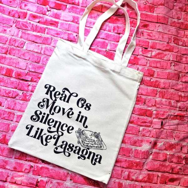 Lasagna Quote Tote Bag, Funny Hip Hop Lyric Gift, Canvas Bag With Pocket 2 The perfect gift for the hip-hop fan or anyone who makes moves in silence! 🤫 Featuring the iconic "Real G's Move In Silence Like Lasagna" lyric, this premium sublimated tote bag is as functional as it is funny. Why this tote stands on business: 💼 Permanent, Vibrant Art: We use sublimation, meaning the ink is dyed directly into the cotton canvas fibers. It’s smooth to the touch and will never fade, peel, or rub off. 🧼✨ Premium Construction: Made from high-quality, medium-weight cotton canvas. It’ (2)