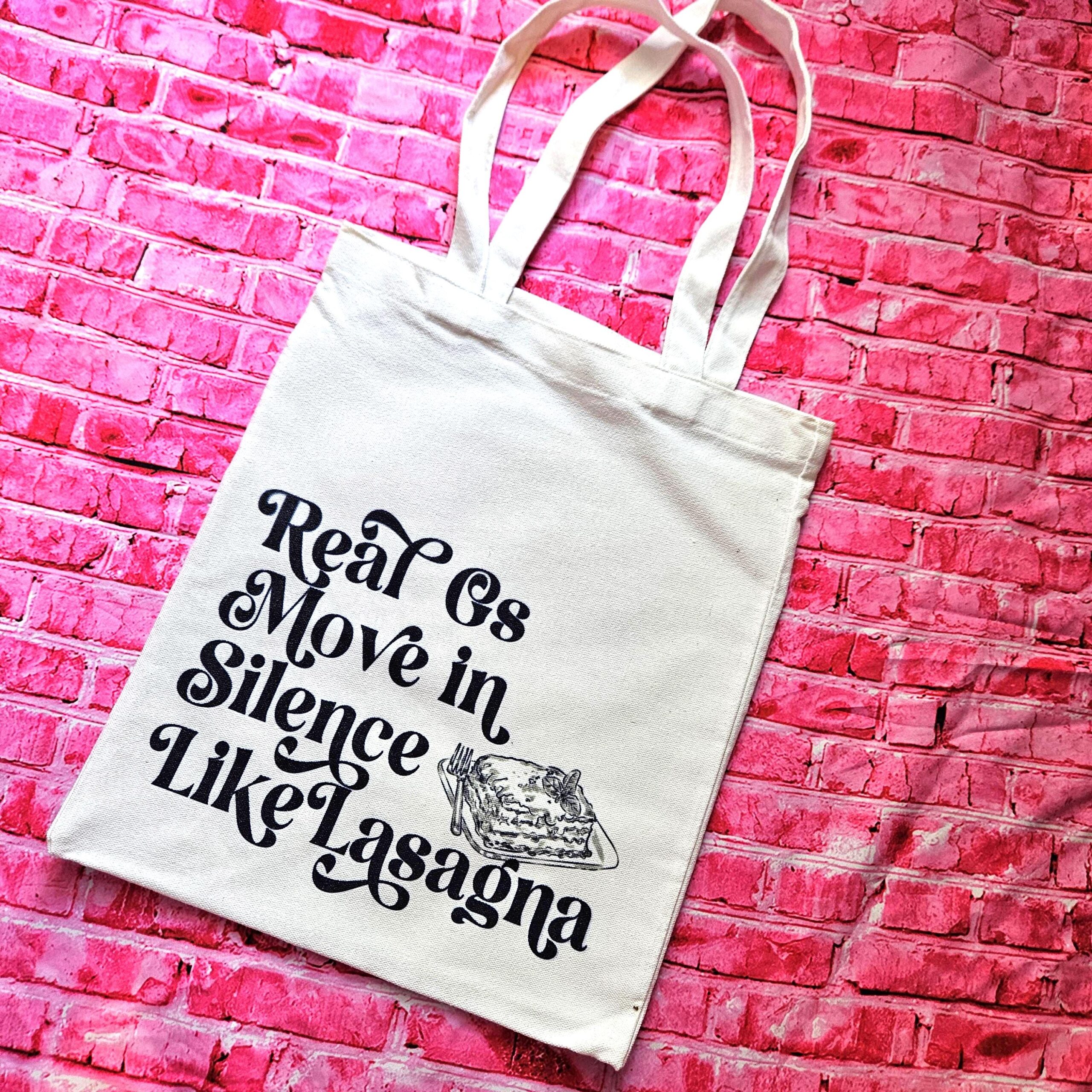 The perfect gift for the hip-hop fan or anyone who makes moves in silence! 🤫 Featuring the iconic "Real G's Move In Silence Like Lasagna" lyric, this premium sublimated tote bag is as functional as it is funny. Why this tote stands on business: 💼 Permanent, Vibrant Art: We use sublimation, meaning the ink is dyed directly into the cotton canvas fibers. It’s smooth to the touch and will never fade, peel, or rub off. 🧼✨ Premium Construction: Made from high-quality, medium-weight cotton canvas. It’ (2)