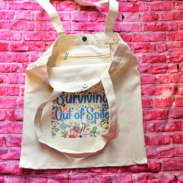 For the fiercely independent friend who thrives on proving people wrong! 💐 Give the gift of unapologetic resilience with this Surviving Out of Spite tote bag. Why this tote stands on business: 💼 Permanent Design: The design is sublimated. The ink is dyed directly into the fibers, meaning it won’t fade, rub off, or lose its punch—no matter how many times you wash it. 🧼✨ Premium Build: Made from high-quality, medium-weight cotton canvas. It’s sturdy enough for your laptop, your protest signs, or a (3)