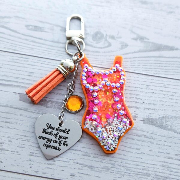 il_fullxfull.7853694546_tgjf Orange Showgirl Era Keychain – Rhinestone Resin Bag Charm with Engraved Quote
