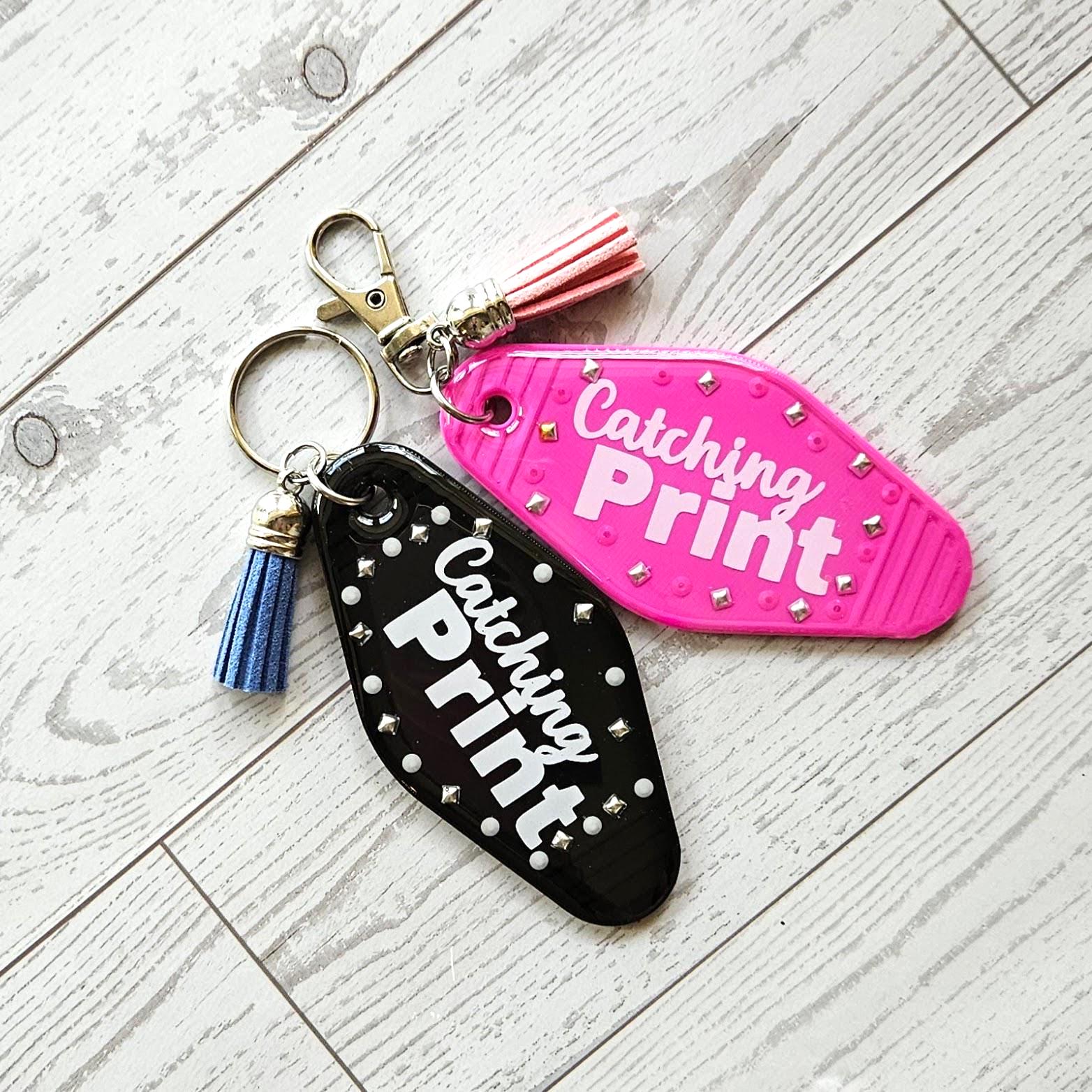 Catching Print Motel Keychain — Funny Cheeky Bag Charm with Studs and Tassel
