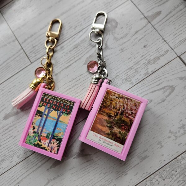 Custom Mini Book Bag Charm, Bookish Keychain, Personalized Reader Gift 14 Your accessories should speak as loudly as you do. This custom mini book bag charm is unlike anything else on Etsy — and I know that because I spent months designing it from scratch to make sure. Send me any book cover link. I'll turn it into a personalized bookish keychain you'll actually want on your bag every single day. THE DETAILS THAT MAKE THE DIFFERENCE ✦ Hand-painted metallic chrome "pages" — gold or silver, finished by hand on every single edge. That gilded look isn't a sticker. It isn' (14)