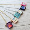 Custom Miniature Book Necklace, Personalized Book Lover Gift, Bookish Jewelry 2 Send us the link, we'll make it tiny. Your favorite book cover, shrunk to charm-sized perfection and hung around your neck. This custom miniature book necklace is a personalized book lover gift — handmade bookish jewelry featuring a 3D printed mini book pendant with hand-gilded pages and an 18" stainless steel chain. ✦ Pendant size: .85" H × .75" W ✦ Construction: 100% handmade and 3D printed from an original SSC design — never mass produced ✦ Cover: Printed from your chosen image, laminated for (2)