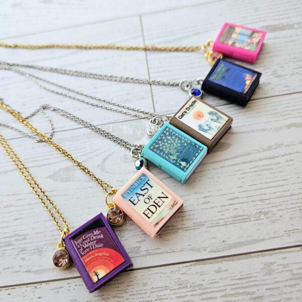 Custom Miniature Book Necklace, Personalized Book Lover Gift, Bookish Jewelry 2 Send us the link, we'll make it tiny. Your favorite book cover, shrunk to charm-sized perfection and hung around your neck. This custom miniature book necklace is a personalized book lover gift — handmade bookish jewelry featuring a 3D printed mini book pendant with hand-gilded pages and an 18" stainless steel chain. ✦ Pendant size: .85" H × .75" W ✦ Construction: 100% handmade and 3D printed from an original SSC design — never mass produced ✦ Cover: Printed from your chosen image, laminated for (2)