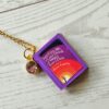 Custom Miniature Book Necklace, Personalized Book Lover Gift, Bookish Jewelry 9 Send us the link, we'll make it tiny. Your favorite book cover, shrunk to charm-sized perfection and hung around your neck. This custom miniature book necklace is a personalized book lover gift — handmade bookish jewelry featuring a 3D printed mini book pendant with hand-gilded pages and an 18" stainless steel chain. ✦ Pendant size: .85" H × .75" W ✦ Construction: 100% handmade and 3D printed from an original SSC design — never mass produced ✦ Cover: Printed from your chosen image, laminated for (9)
